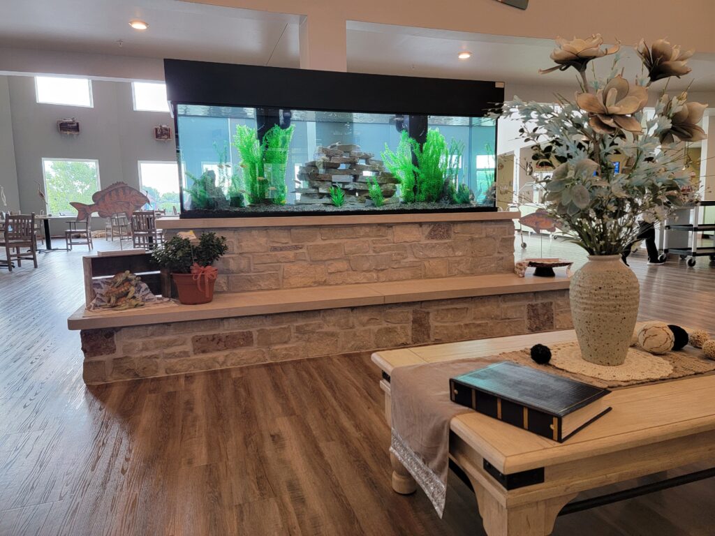 A big aquarium on a stone stand in spacious dining room